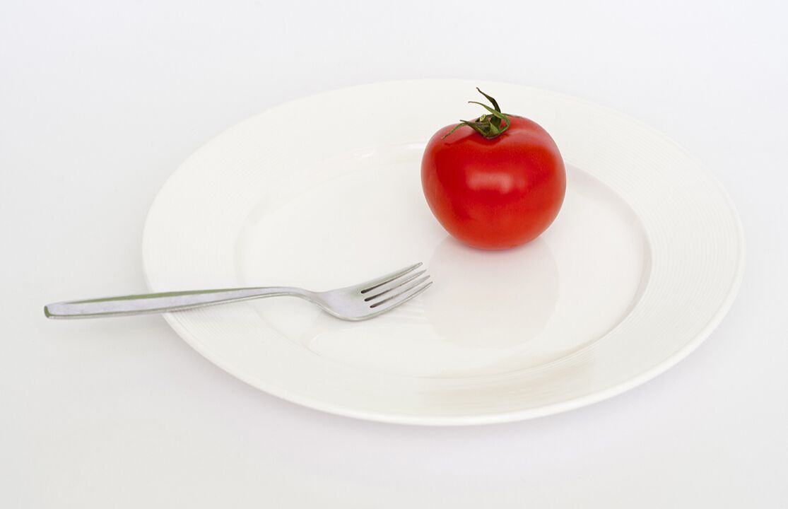 pomodoro con una forchetta su un piatto